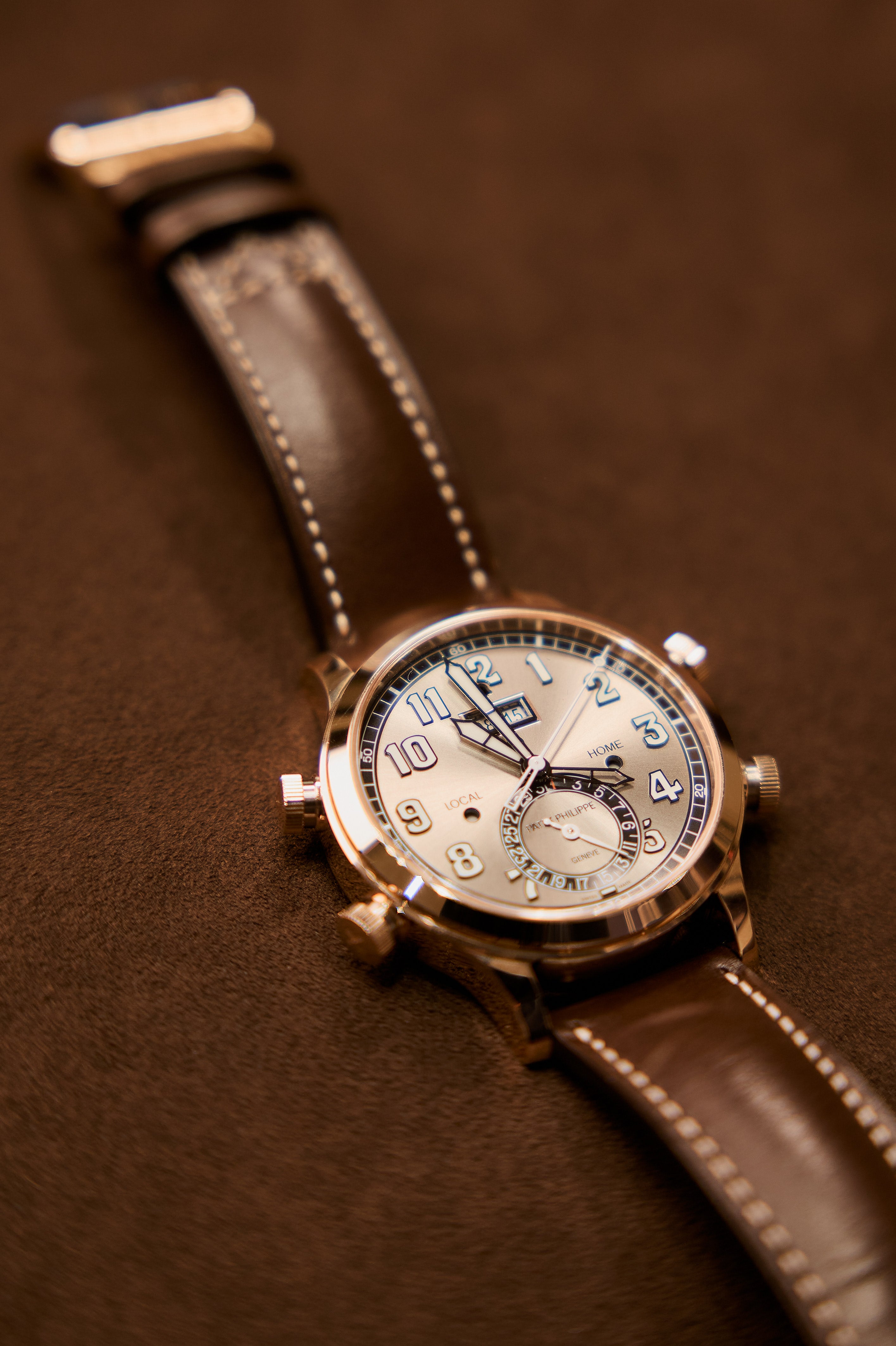Vintage wristwatch with brown leather strap on a brown background