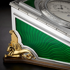 Luxury clock with green face and gold sphinx decoration on a dark background