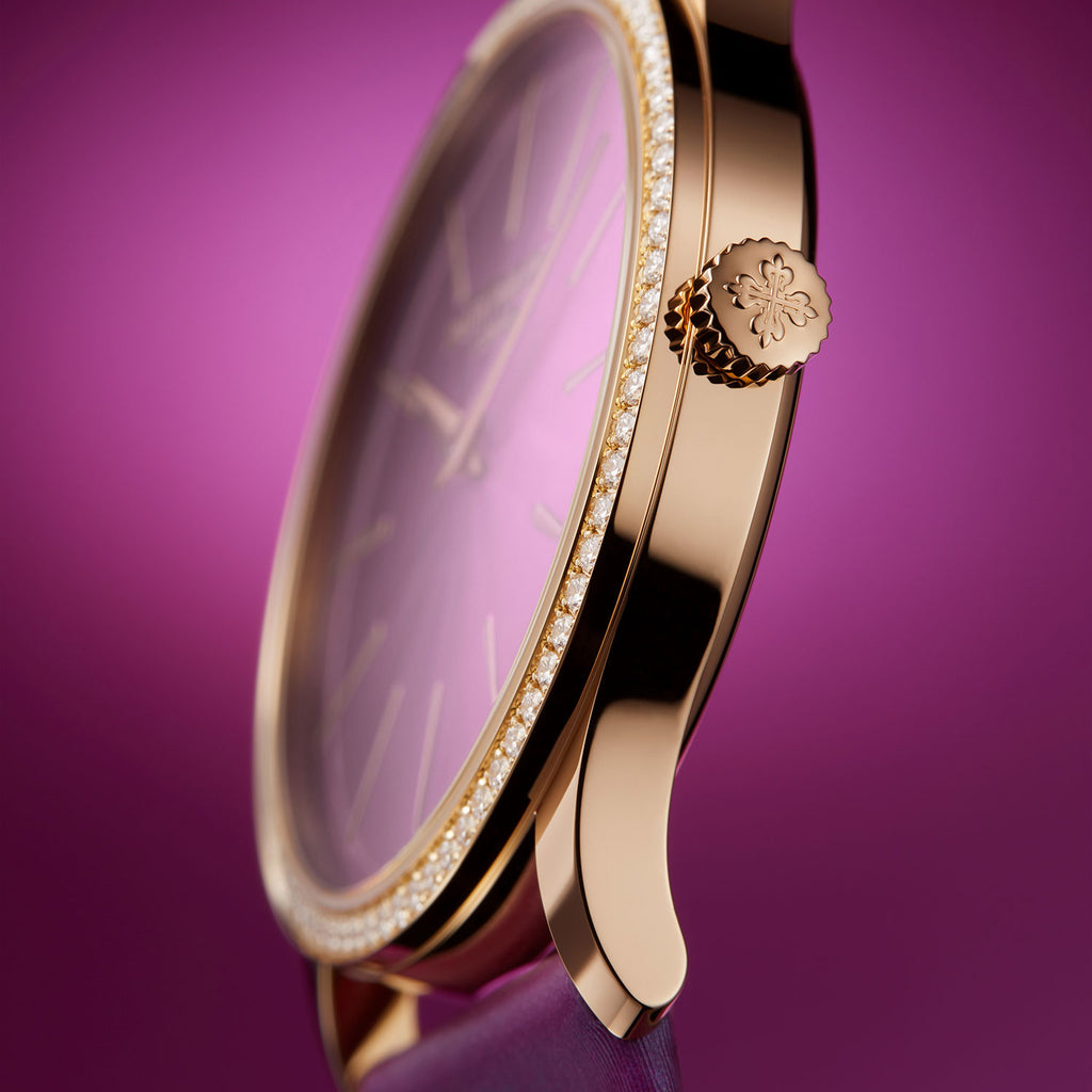 Gold watch with purple face on a purple background