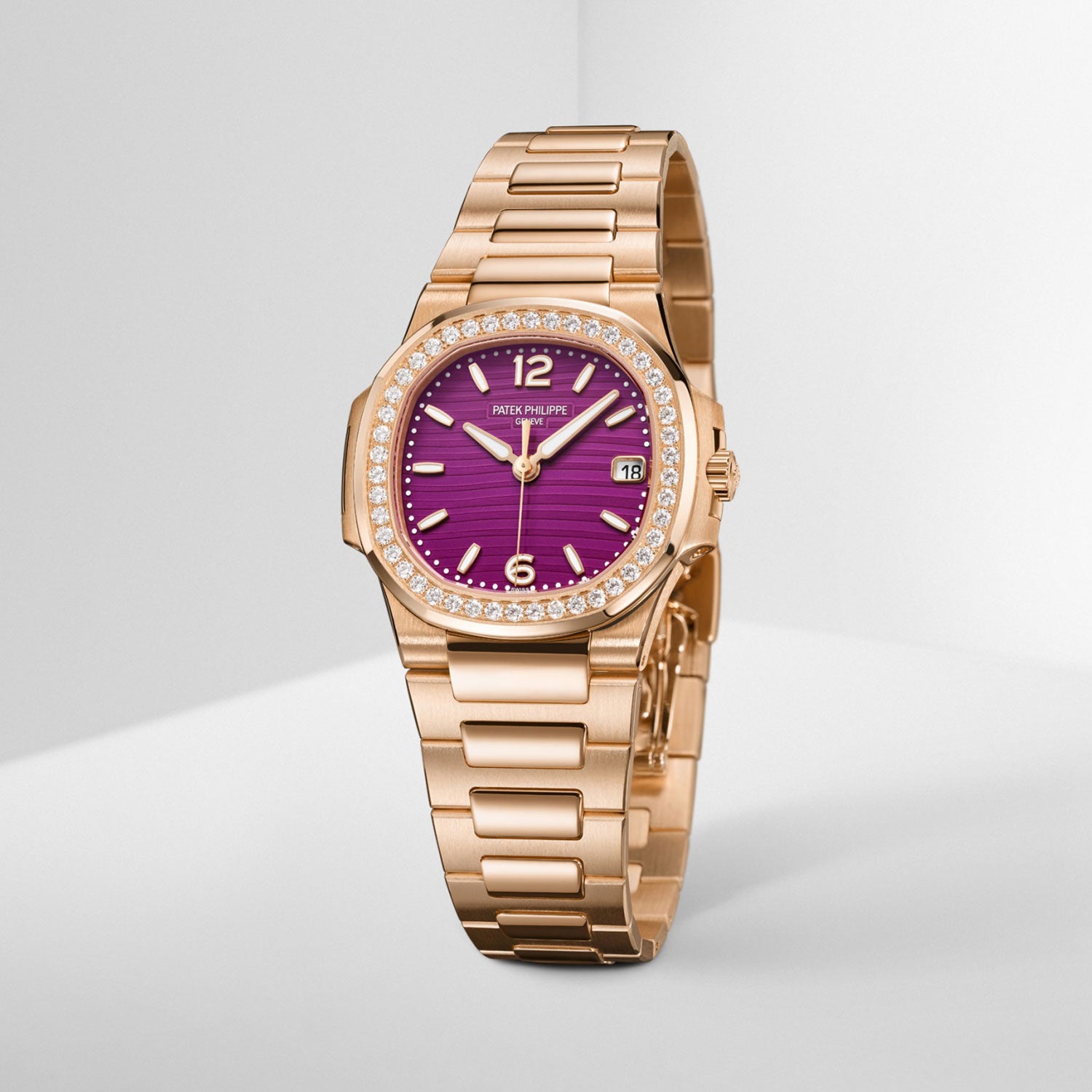 Gold watch with a purple face on a light gray background