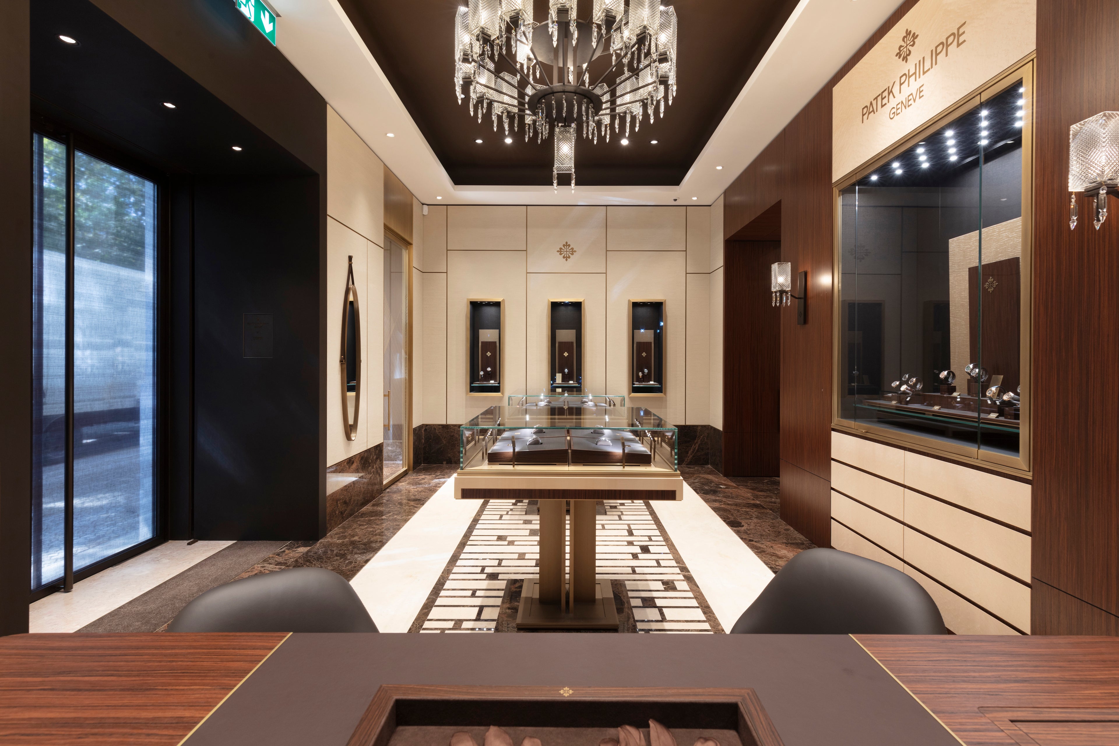 Luxurious interior with a chandelier, table, and wall art in a high-end setting.