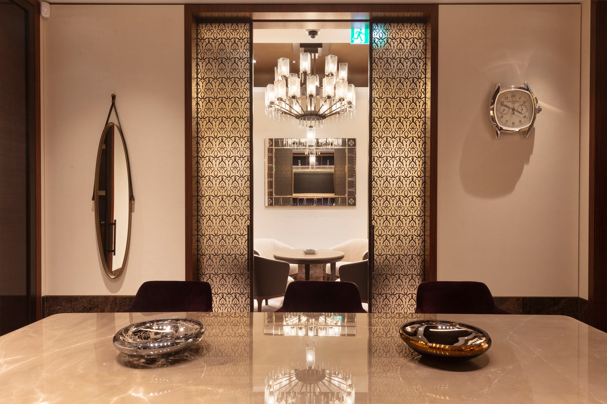 Dining room with marble table, chairs, and decorative wall art.